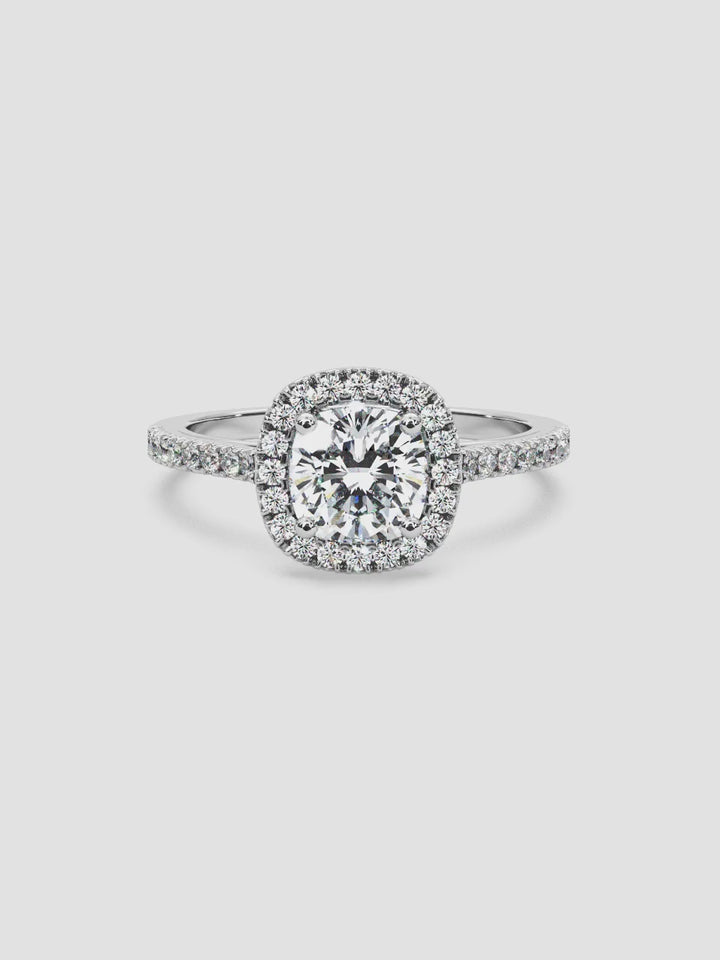 Video showcasing the Soiree ring, highlighting its cushion-cut diamond center stone, halo setting, and pavé diamond band in 18K white gold.