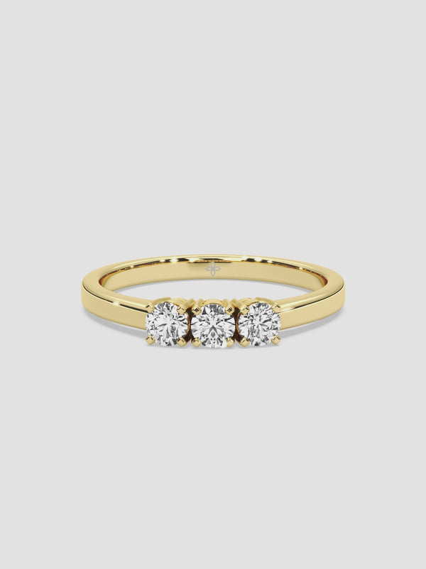 Video of the “Un, Deux, Trois” ring, featuring three sparkling round diamonds aligned in a row on a sleek 18k yellow gold band. The prong settings accentuate the diamonds’ shine.