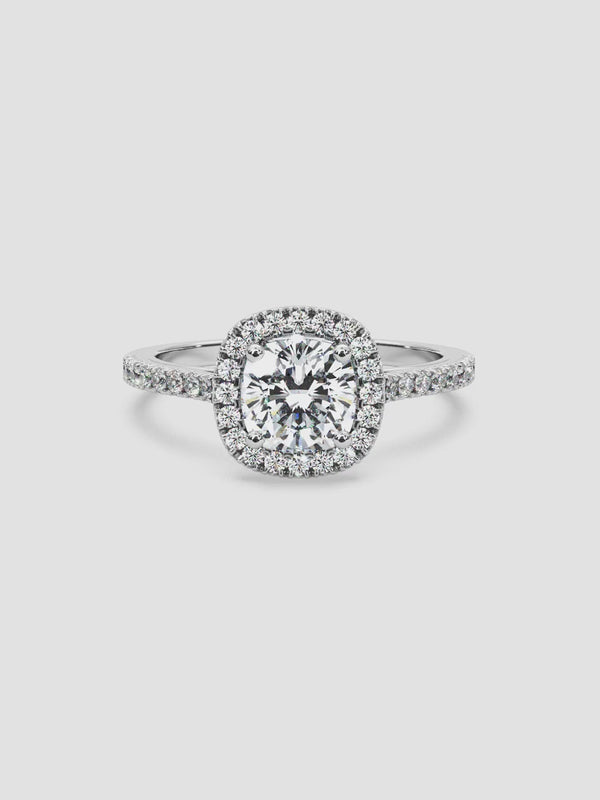 Video showcasing the Soiree ring, highlighting its cushion-cut diamond center stone, halo setting, and pavé diamond band in 18K white gold.